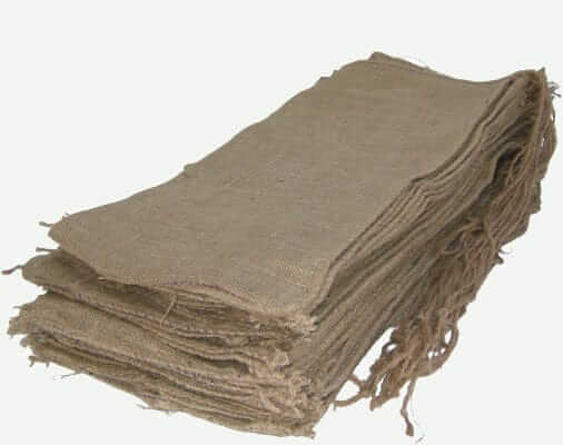 A pile of standard duty jute hessian unfilled sandbags