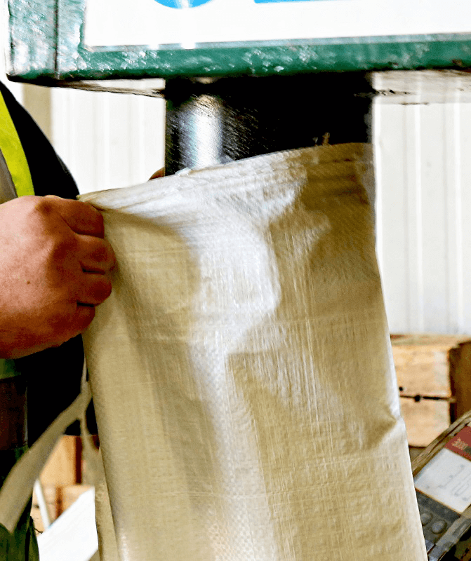 an operative filling an empty sandbag with sand