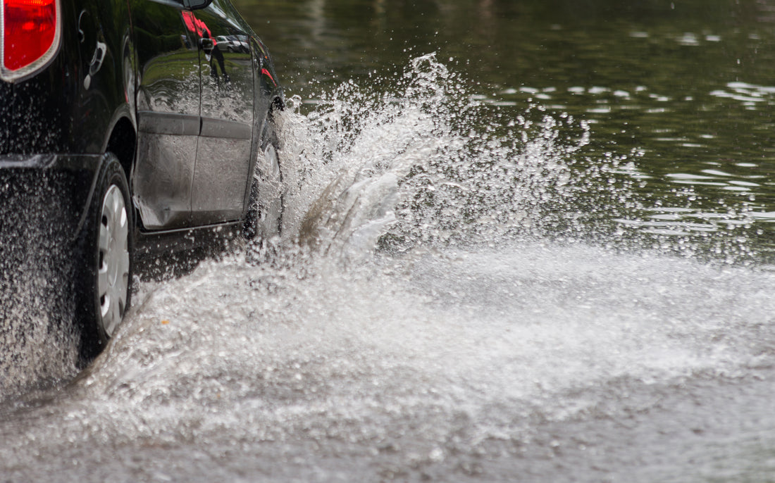 a car driving through heavy rain water