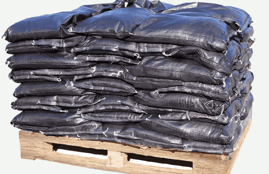 Black heavy duty woven pp uv protected sandbags on a wooden pallet.