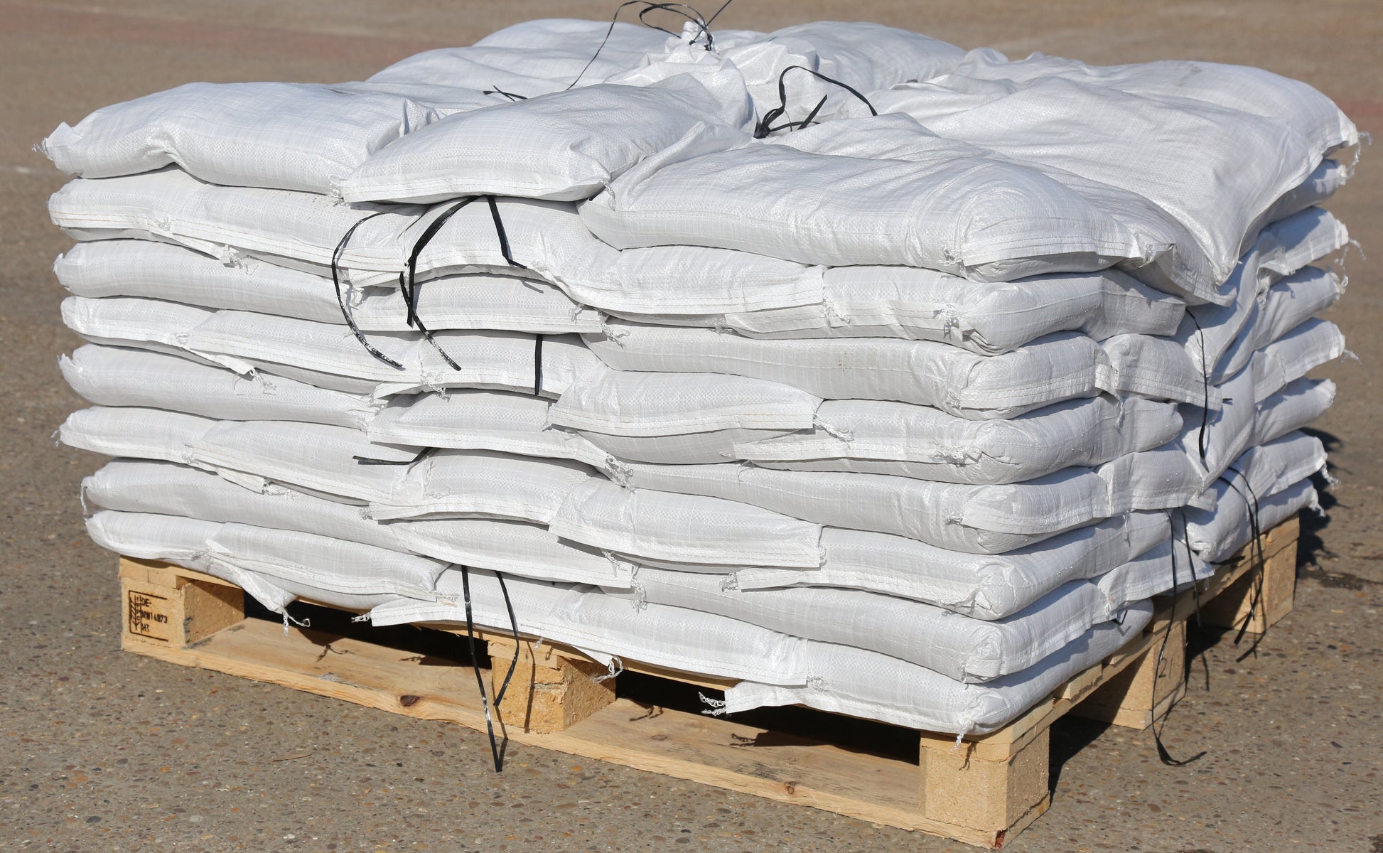 A pallet of standard white woven polypropylene filled sandbags